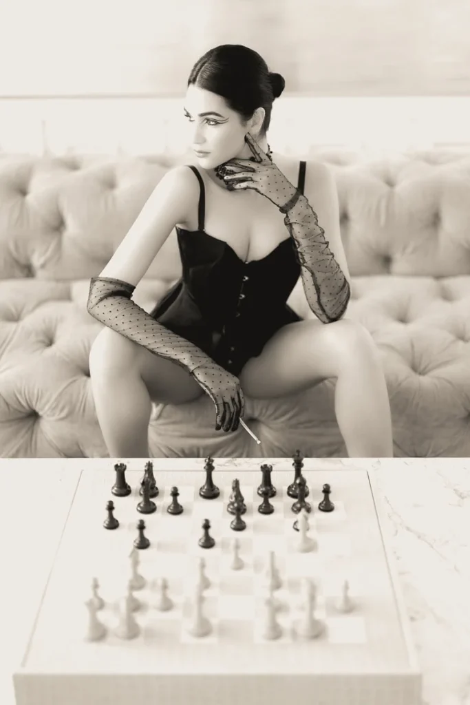 A woman wearing Agent Provocateur lingerie poses elegantly in the natural light of a Haussmann apartment window during a private Paris boudoir photography session.