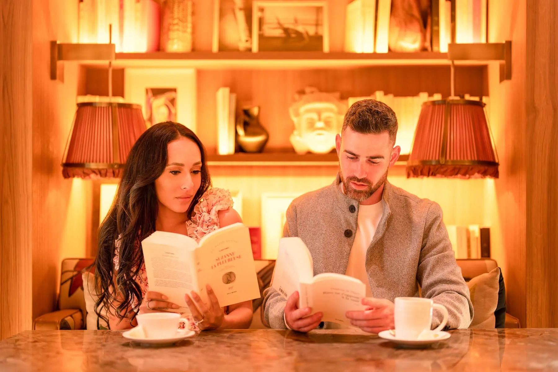 Paris couple photography session at sidewalk cafe with engaged couple reading books - stylish engagement photos by professional Paris photographers