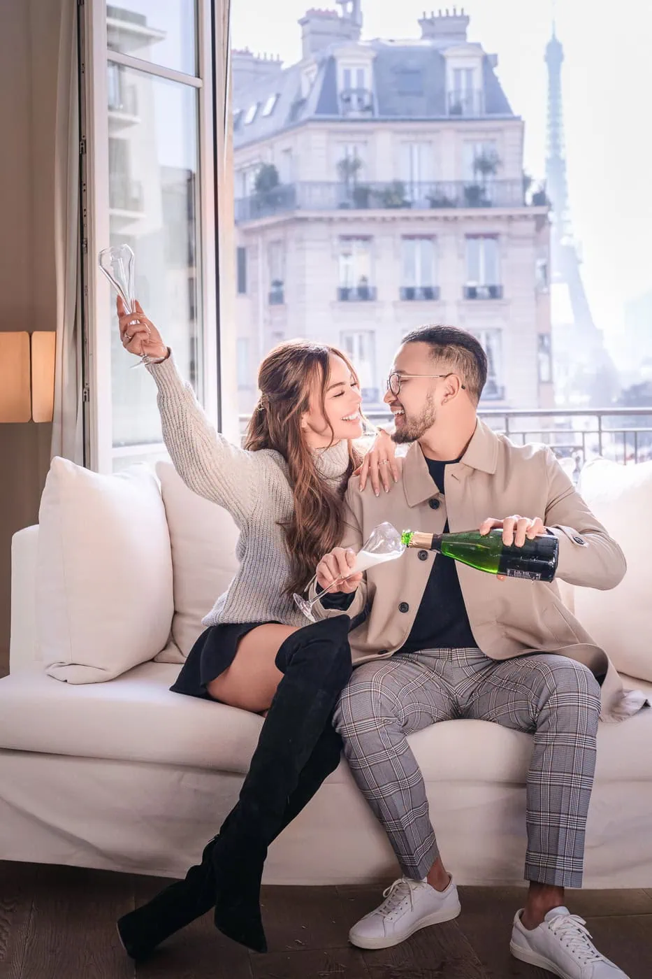 Couple celebrating engagement with champagne at Le Metropolitan Paris hotel suite, Paris engagement photographer session