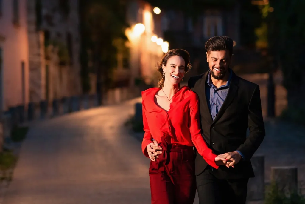 Couple walking hand in hand on rue Abreuvoir Montmartre near La Maison Rose at night, Paris engagement photographer