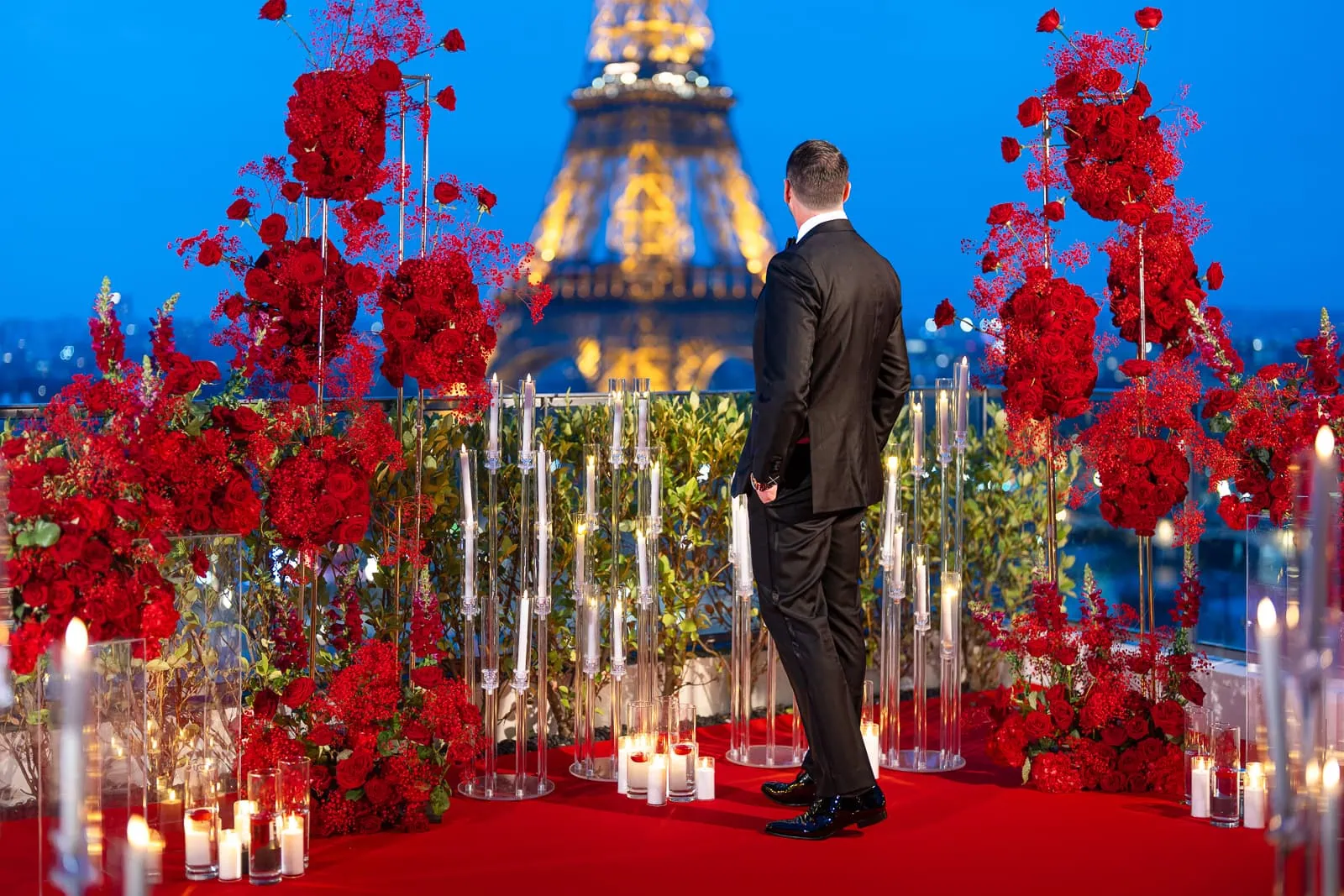 Man in tuxedo at Shangri-La Paris penthouse with red roses and Eiffel Tower view during blue hour, luxury photographer