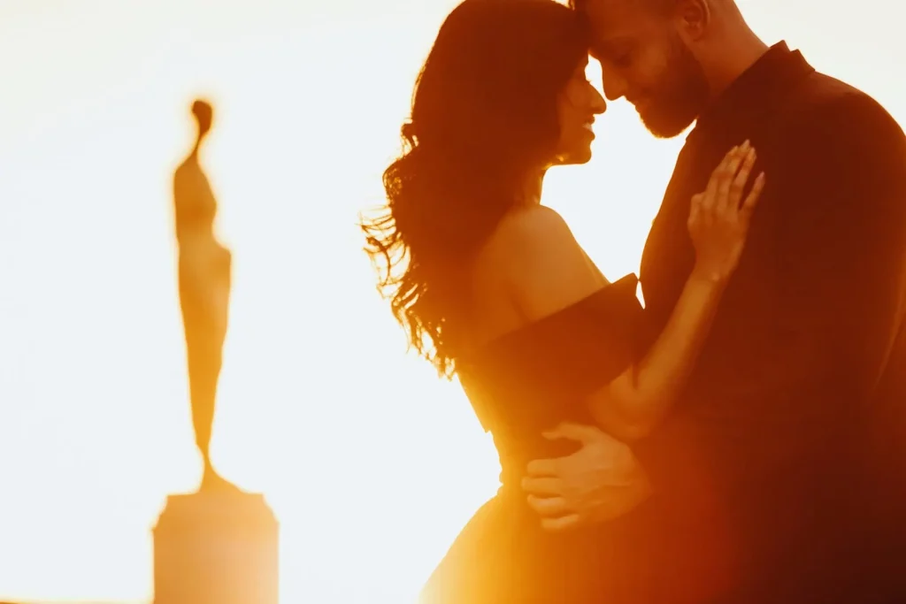 Indian couple touching foreheads at Trocadéro sunrise with golden statue backdrop, Paris anniversary photographer session