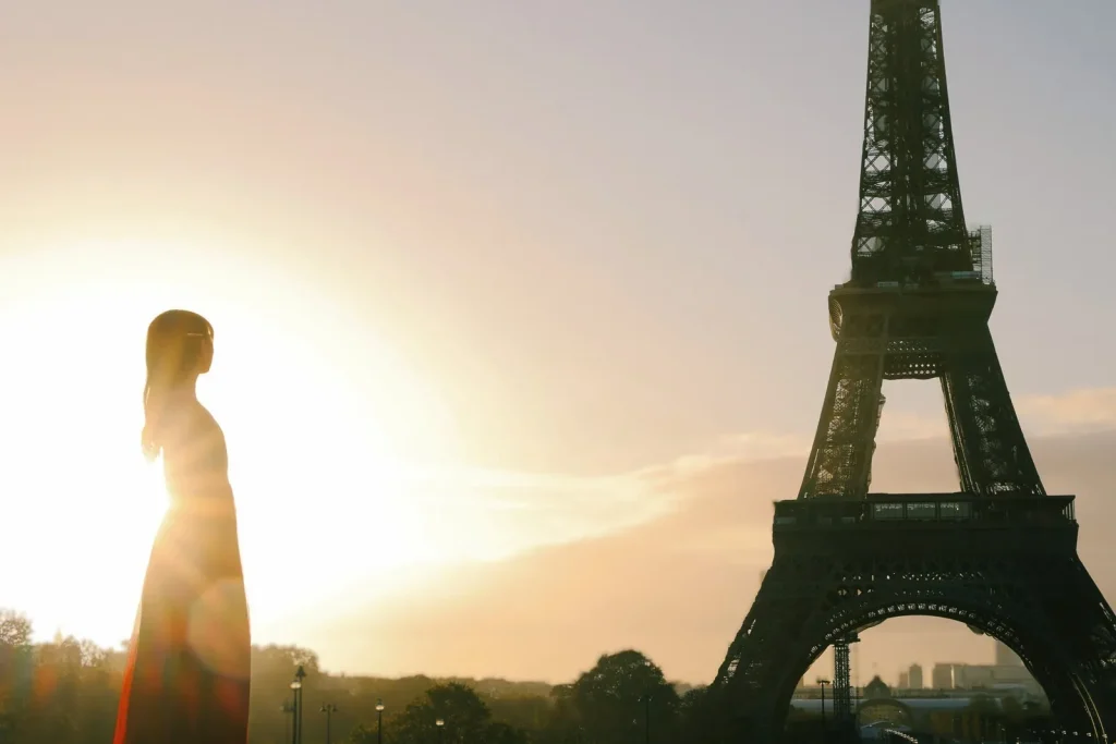 Woman in red outfit silhouette with winter sunrise halo at Trocadéro looking toward Eiffel Tower, Paris photographer session